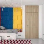 Łóżko w pokoju dziecięcym z kolorowymi geometrycznymi kaflami na ścianie